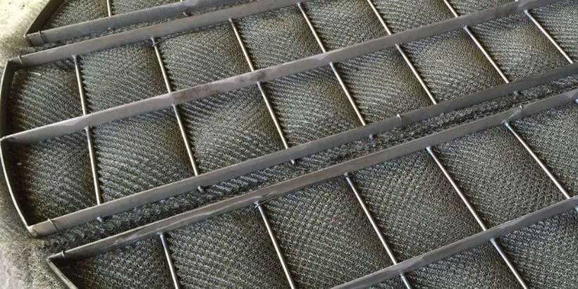 A piece of stainless steel wire mesh demister pad on the ground.